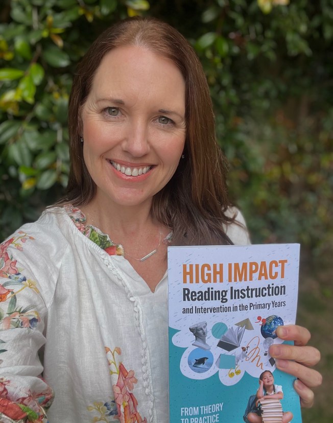 Julie Scali holding her book, High Impact Reading Instruction and Intervention in the Primary Years